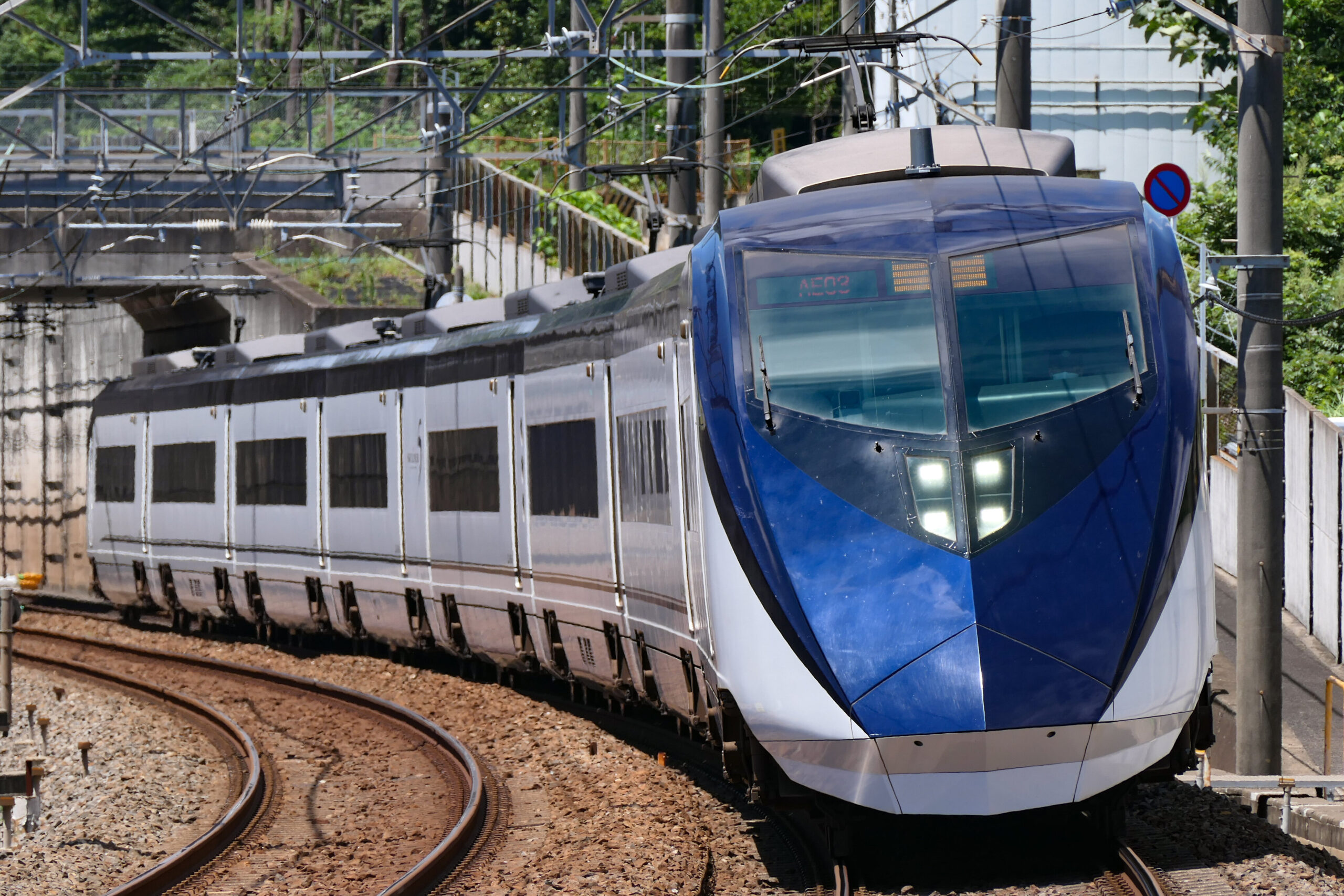 Blue and white Keisei Skyliner train traveling on tracks in Tokyo
