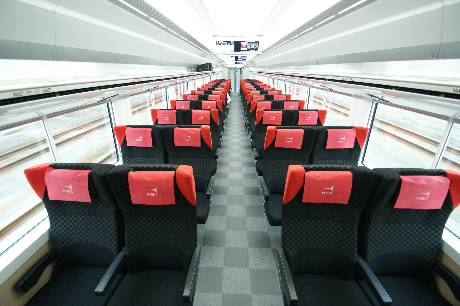 Rows of black and red reserved seats inside a Narita Express train