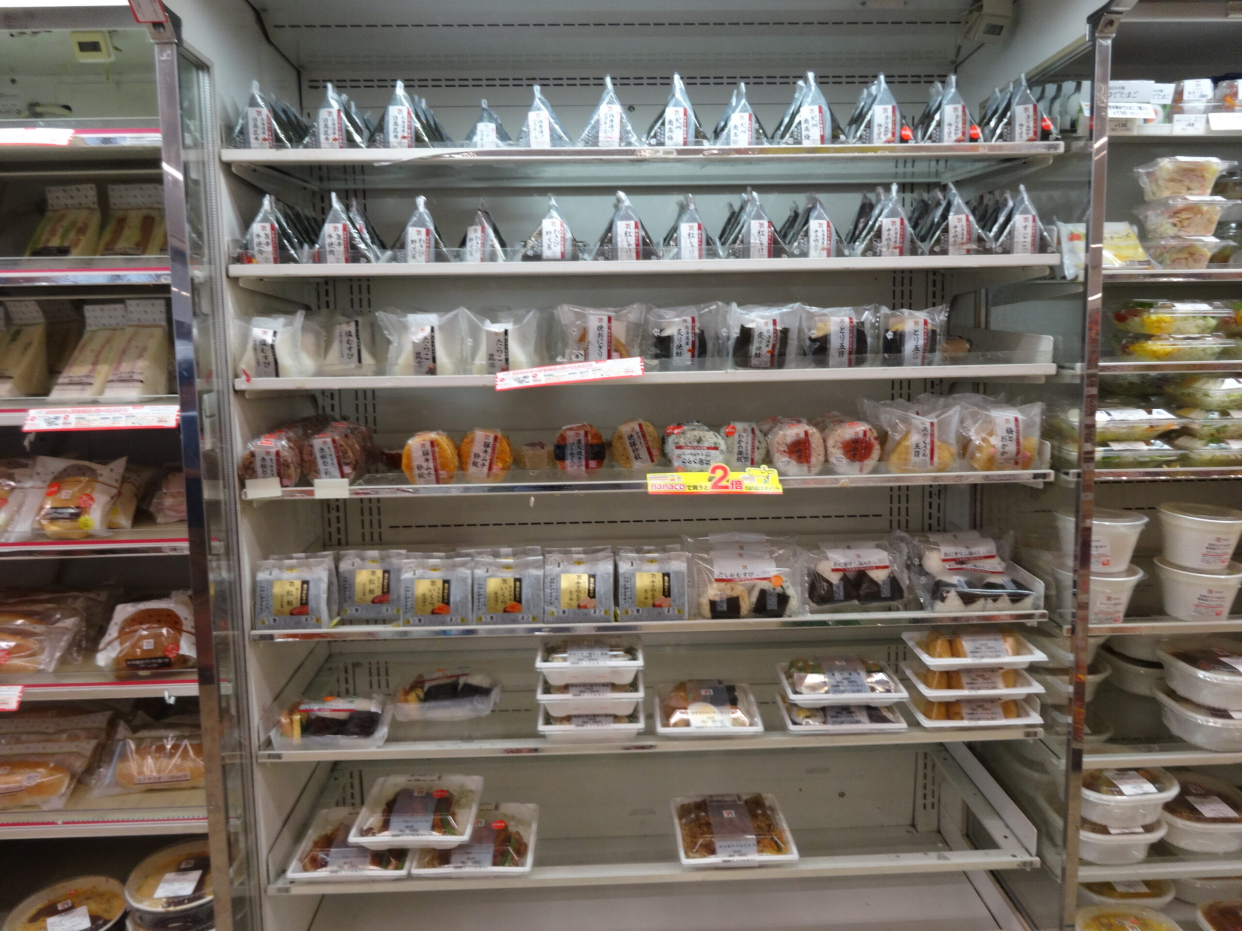 Refrigerated shelves filled with onigiri and prepared meals in a Japanese convenience store