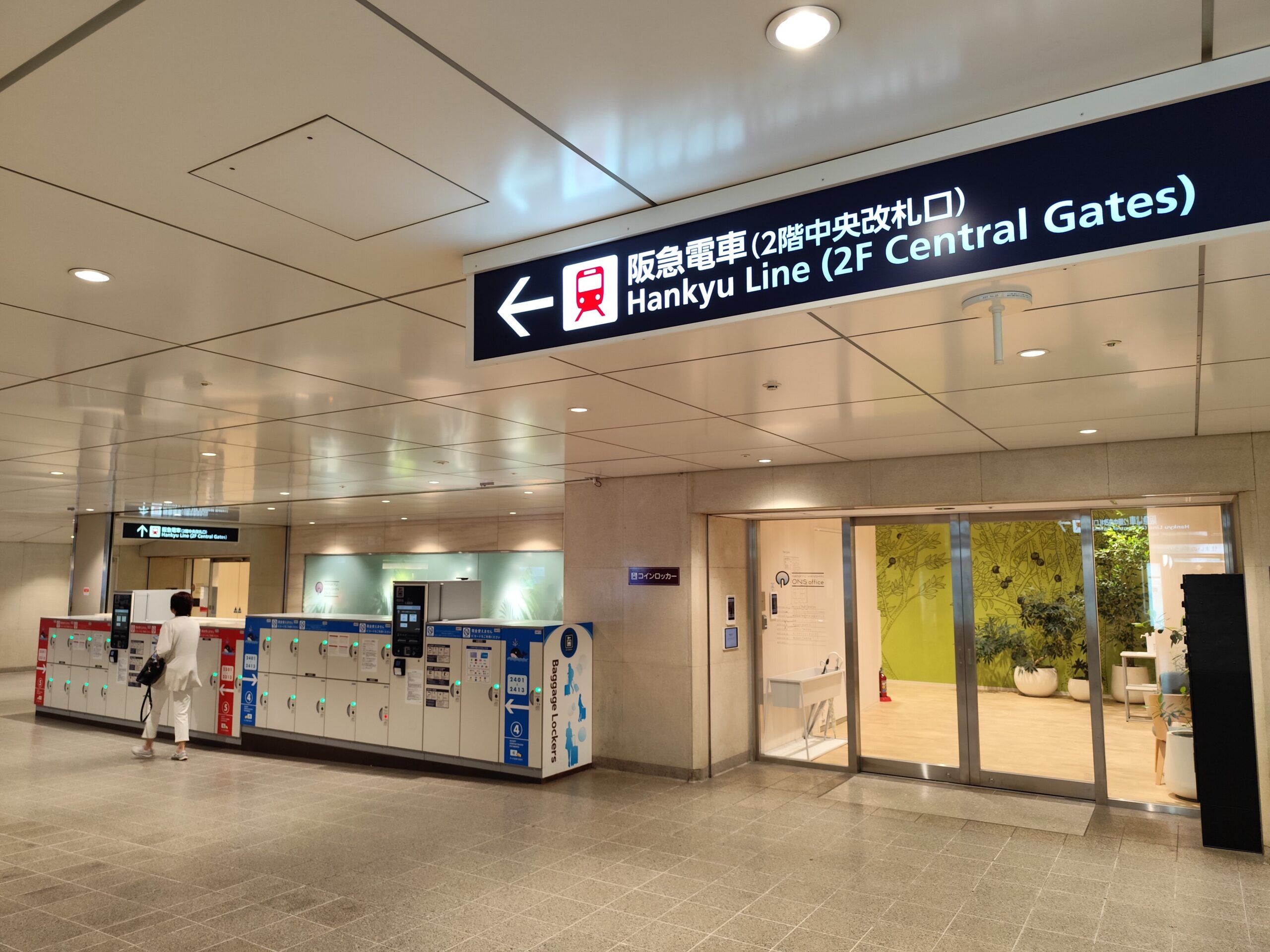 Coin lockers beneath directional signs inside Osaka Station