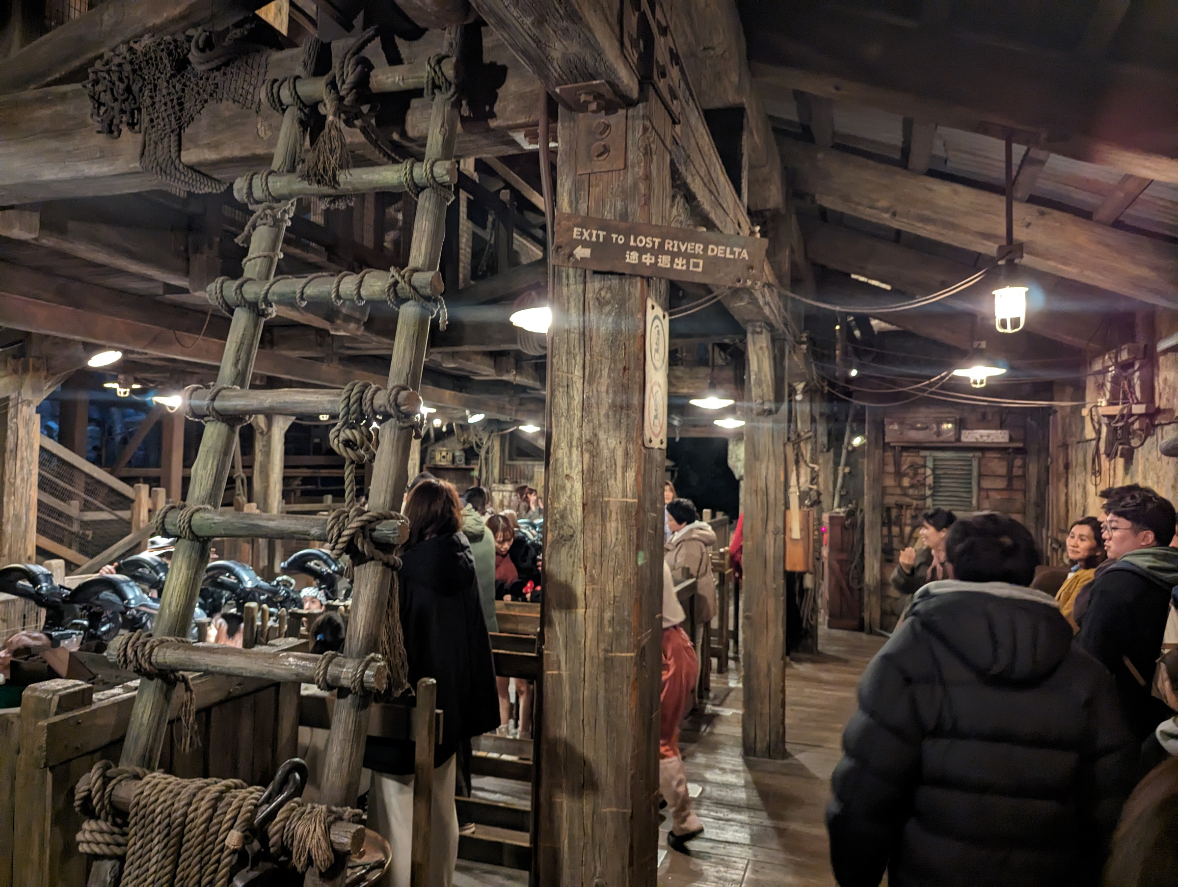 Guests beside the coaster cars inside the timber-framed Raging Spirits loading station.