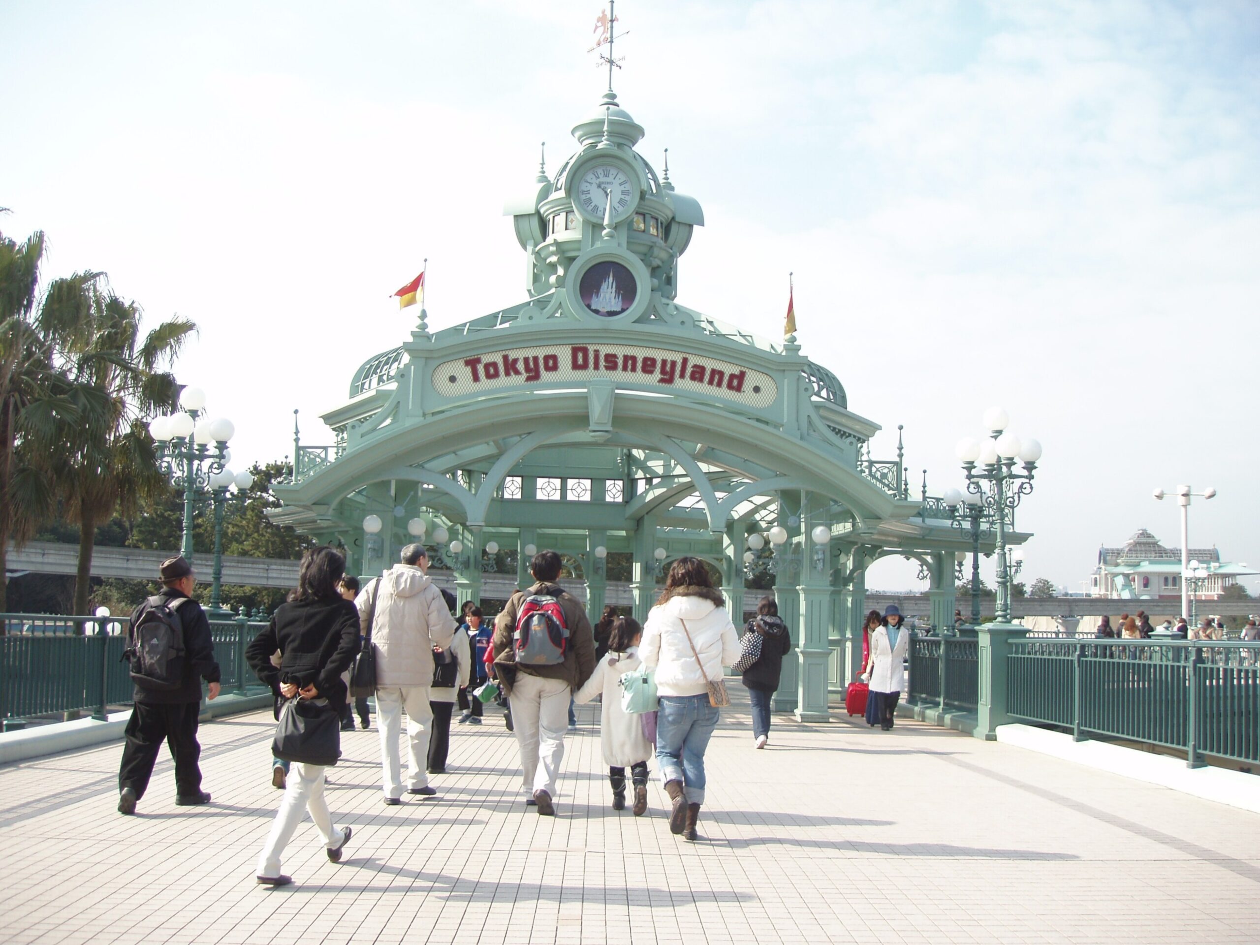 Visitors walking toward the entrance arch of Tokyo Disneyland