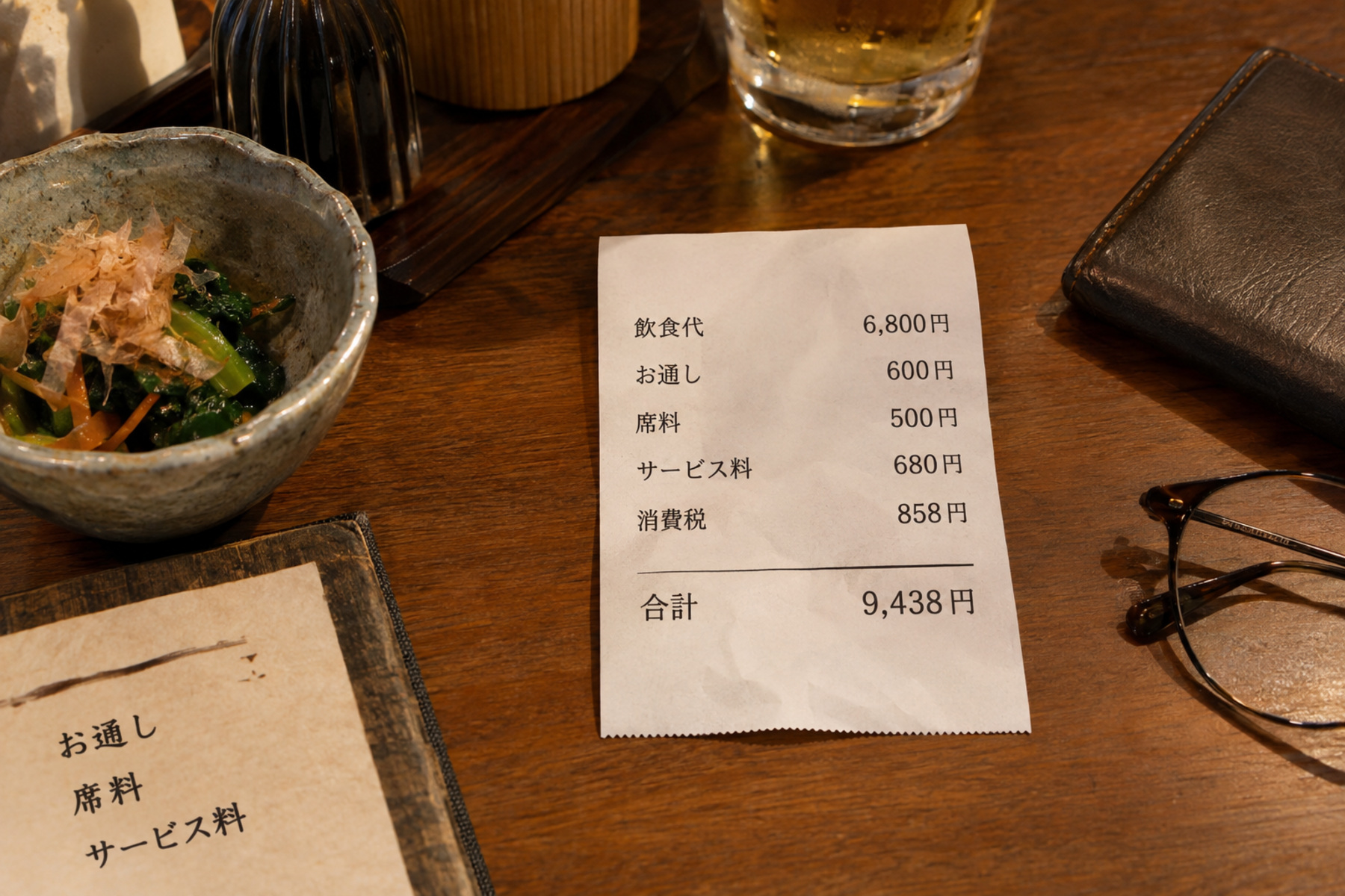 Japanese restaurant receipt showing total, service charge and seat charge beside an otoshi dish