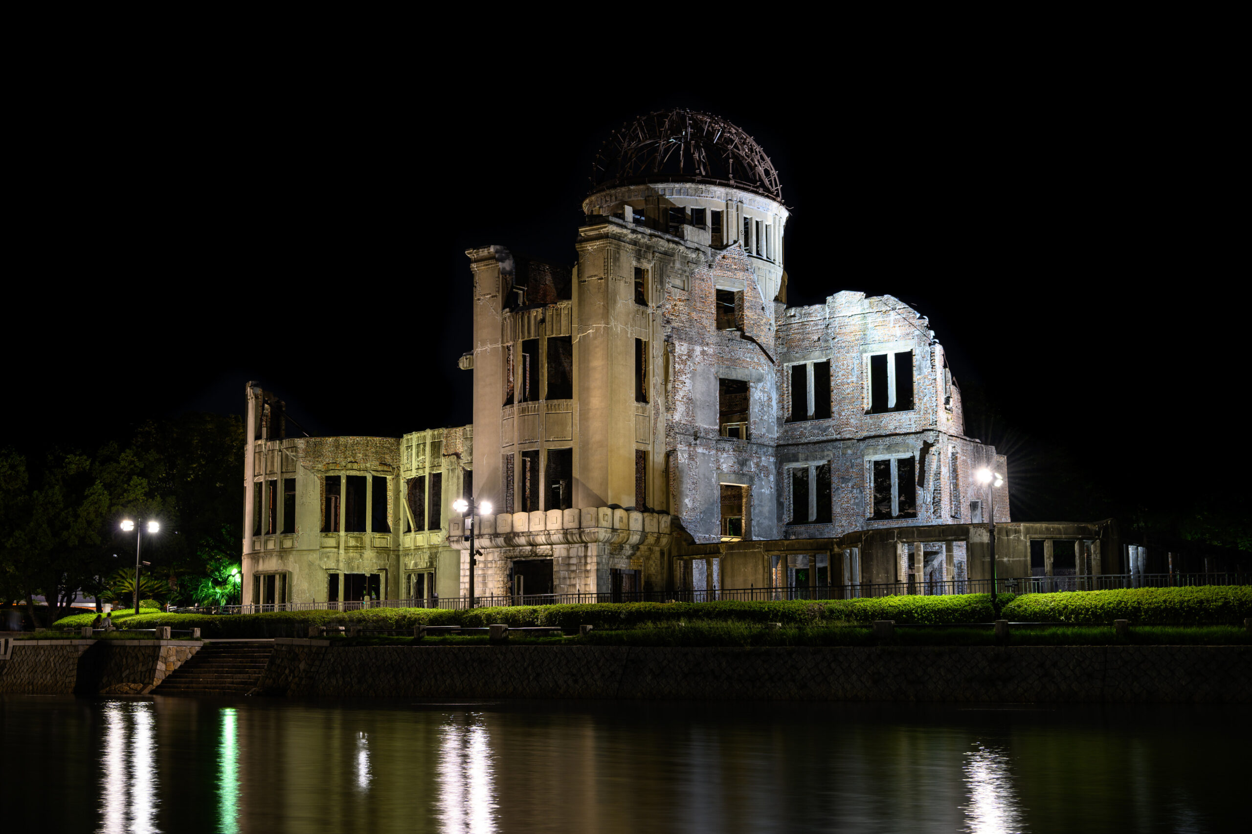 Atomic Bomb Dome illuminated beside the river at night in Hiroshima