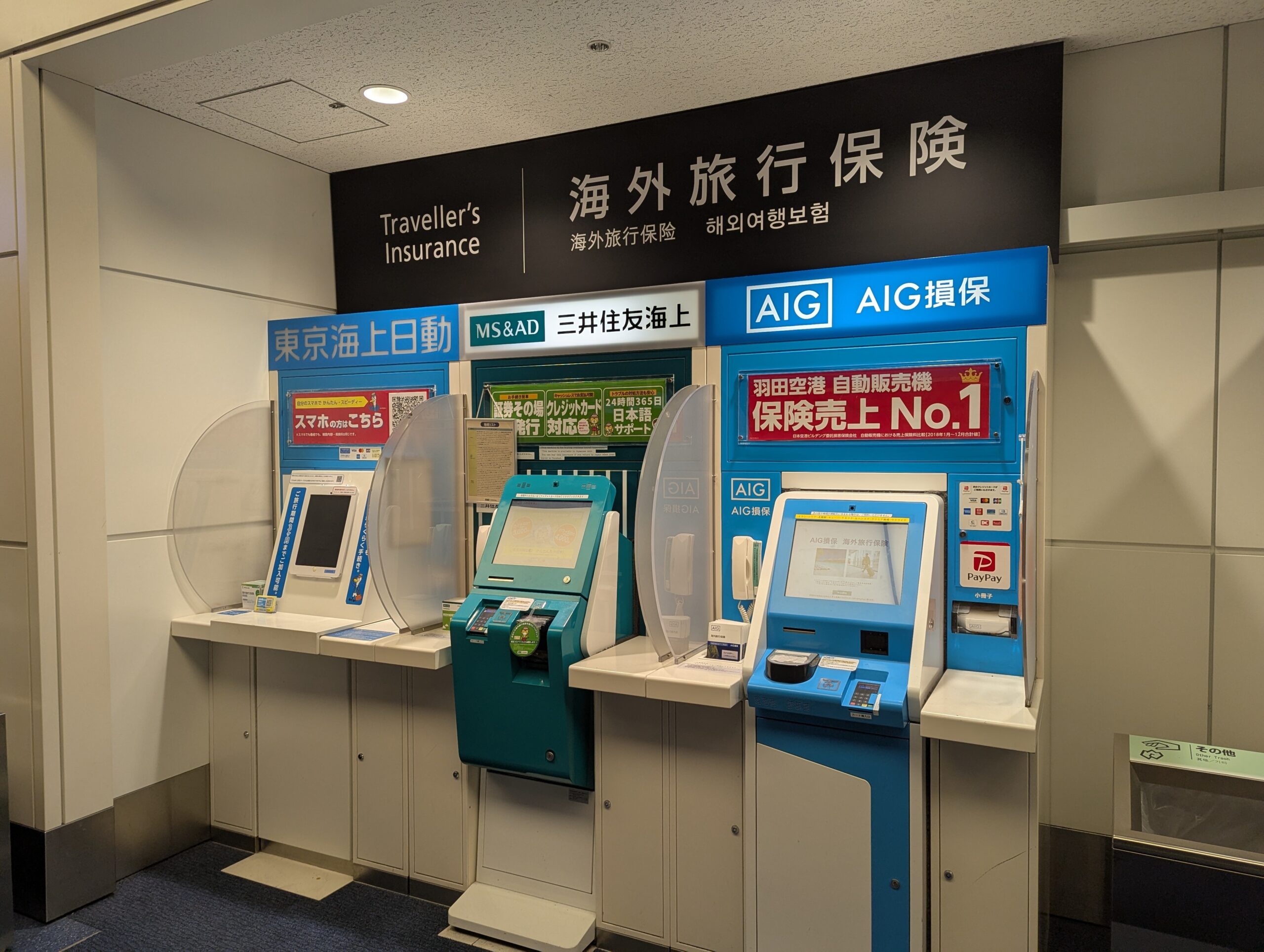 Travel insurance vending machines with genuine Japanese and English signage at Haneda Airport