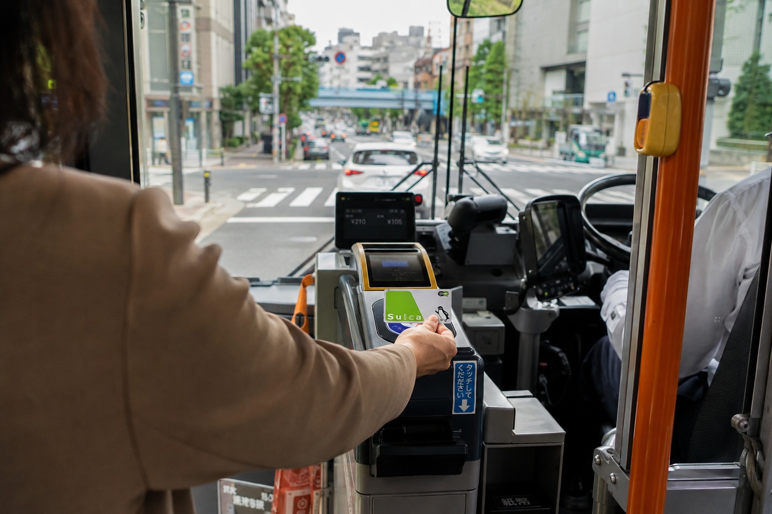 Passenger tapping a Suica card on a bus reader in Japan