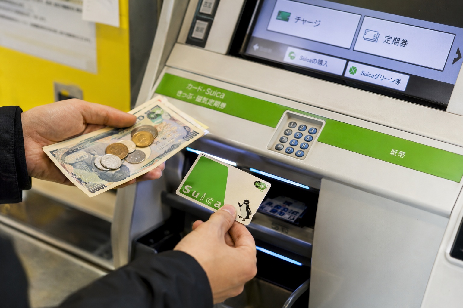 Traveler recharging a Suica card at a station ticket machine in Japan