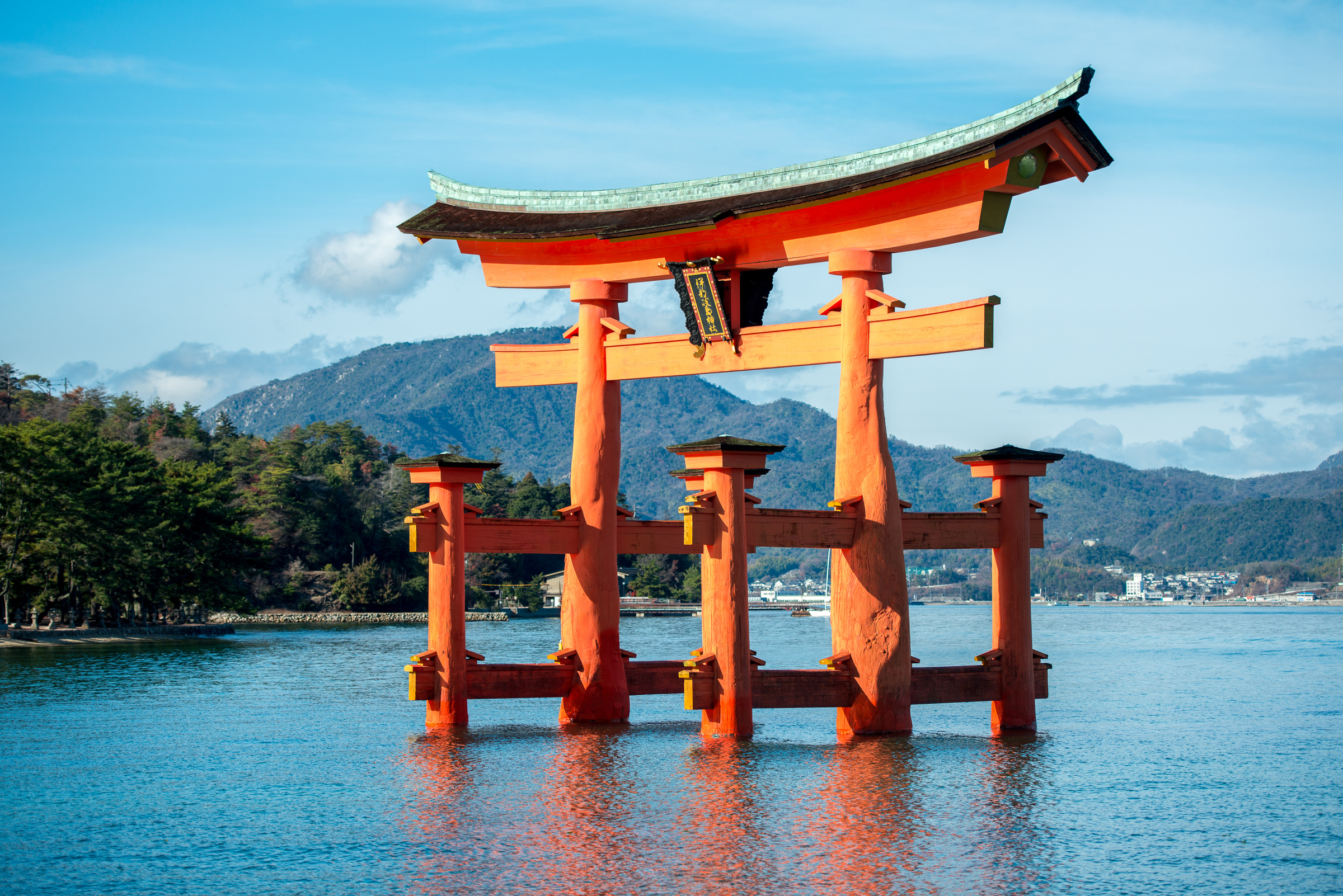 The orange torii of Itsukushima Shrine stands in the sea at Miyajima.
