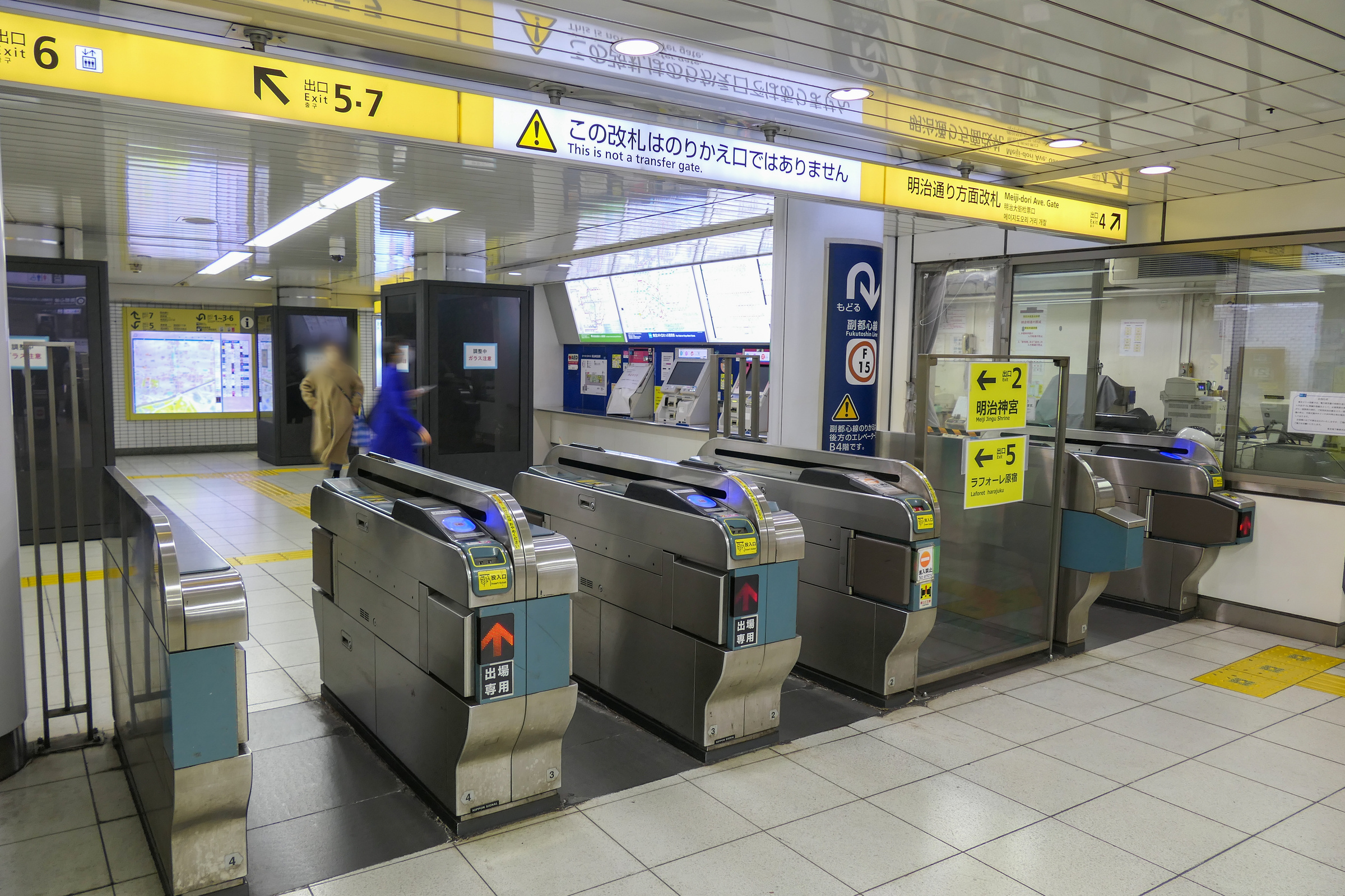 Meiji-jingumae ticket gates beneath yellow exit signs and a notice that this is not a transfer gate.